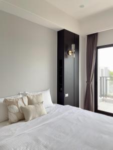 宜兰市沐筑民宿的白色的卧室设有一张大床和一个窗户