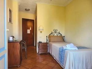 罗通多港科隆纳圣马可酒店的一间卧室配有一张床和一张桌子及椅子