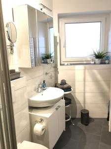 威廉港Ferienwohnung Hallix - Wilhelmshaven的白色的浴室设有水槽和镜子