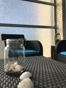威廉港Ferienwohnung Hallix - Wilhelmshaven的天井桌子上一罐贝壳