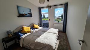 里加Float House Nr 659的一间卧室配有一张带黄色枕头的床和一扇窗户