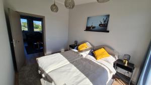 里加Float House Nr 659的一间卧室配有带白色和黄色枕头的床