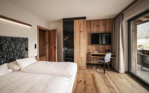 佩尔蒂绍Wagnerhof Apartments的一间卧室配有一张床、一张书桌和一台电视