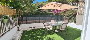 滨海圣波尔Hauzify I Apartaments Can Pi的庭院配有桌椅和遮阳伞。