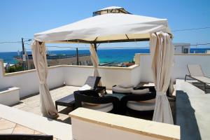 托雷苏达Hotel Villa Giovanna的一个带遮阳伞和椅子的庭院和大海