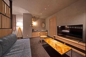高山hotel around TAKAYAMA, Ascend Hotel Collection的带沙发和大电视的客厅