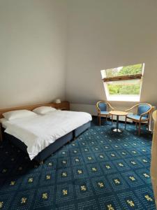 威斯巴登Hotel Am Schlosspark , Wiesbaden的卧室配有一张床和一张桌子及椅子