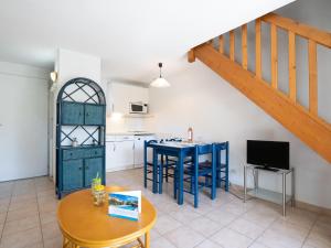 阿格德角Holiday Home Les Lavandines 1-6 by Interhome的一个带蓝色桌子的厨房和一个带楼梯的厨房