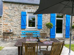 洛基雷克Holiday Home Bleue - LOQ206 by Interhome的桌椅和遮阳伞位于房子前