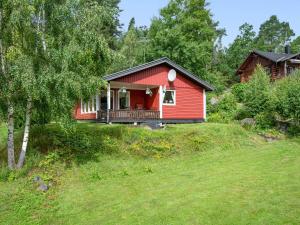 穆塔拉Chalet Västanvik Snickarhagen - OST047 by Interhome的一座带庭院的山丘上的红色房子