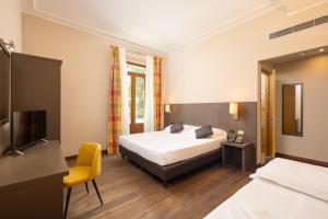 佛罗伦萨贝坦尼亚别墅酒店的一间卧室配有一张床和一张黄色椅子