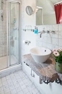 Bad EmstalHotel Der Grischäfer的白色的浴室设有水槽和淋浴。