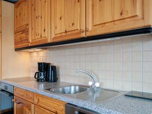 韦松纳Apartment Apt-212X by Interhome的一个带水槽和木柜的厨房台面