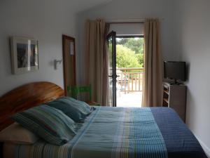 卡普费雷杜章酒店的一间卧室设有一张床和一个滑动玻璃门