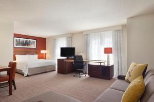 乔普林乔普林旅居酒店的配有一张床和一张书桌的酒店客房