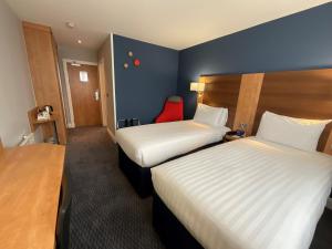 纽尼顿纳尼顿假日快捷酒店的酒店客房,设有两张床和一张红色椅子