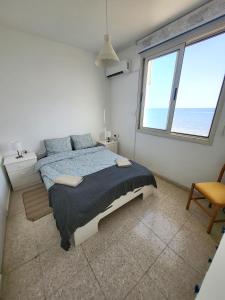 皮尔瓦利亚Mattis Seafront Beachhouse的一间卧室设有一张大床和一个大窗户