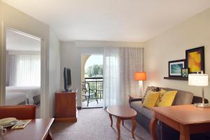 乔普林乔普林旅居酒店的带沙发的客厅和带阳台的客房。
