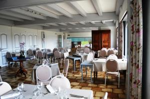 Grande Riviere卢格兰瓦酒店的一间设有白色桌椅的用餐室