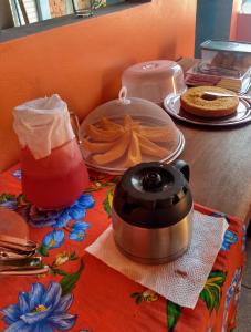 巴雷里尼亚斯Pousada Pérola do Rio的桌子上放着饮料,放着慢锅子