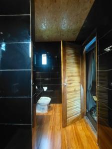 Ban Cha-omCountry Cafe & Camping的一间带卫生间和黑色墙壁的浴室