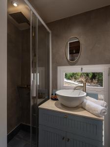 干尼亚Artemide city places _Leon tiny suite的一间带水槽和玻璃淋浴的浴室
