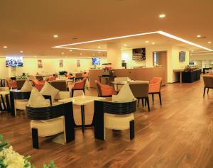 亚的斯亚贝巴Skylight In-Terminal Hotel的一间在房间内配有桌椅的餐厅