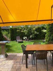 卡尔斯哈根Sommergarten 33的庭院配有桌椅和遮阳伞。
