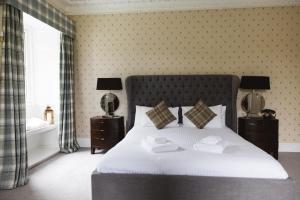 Edinbain格瑞斯奥尼斯屋酒店的一间卧室配有一张床,上面有两条毛巾