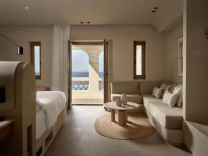 米克诺斯城Domes Noruz Mykonos的带沙发、床和桌子的客厅