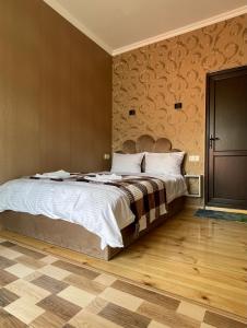 卡兹贝吉Sunny guesthouse的一间卧室设有一张大床,铺有木地板