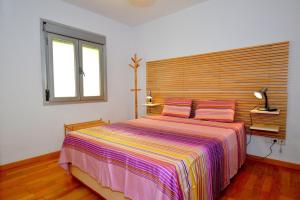 坎帕斯蒂利亚Coqueto apartamento a pocos metros de playa的一间卧室配有一张大床和木制床头板