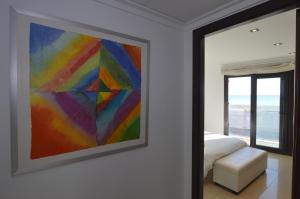坎帕斯蒂利亚Apartamento delante del mar的卧室墙上的彩色画