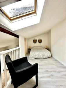 克莱蒙费朗C La reserve - St ROSE Ethnique的一间卧室配有一张床、一把椅子和天窗