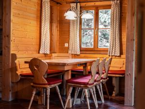 图拉彻霍赫Alpin-Hütten auf der Turracherhöhe Haus Murmeltier by S4Y的一间带木桌和椅子的用餐室