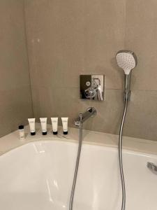 富查伊拉Address Resort Apartments Fujairah - 2 bedroom apartment的带淋浴头的浴缸的浴室