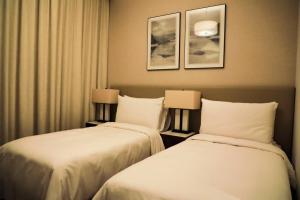 富查伊拉Address Resort Apartments Fujairah - 2 bedroom apartment的配有2盏灯的酒店客房的2张床