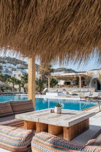 伊奥斯乔拉伊奥斯伊亚罗斯酒店的一个带桌椅的庭院和一个游泳池