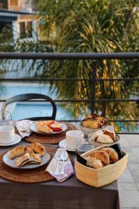 拉法尔达Good Life Resort的餐桌,盘子上放着食物和面包篮