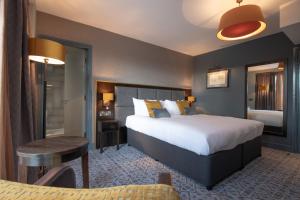 索兹The Old Borough Hotel - Wetherspoon的酒店客房设有一张大床和一张桌子。