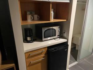 檀香山~Four-star serviced apartment的一间带微波炉和冰箱的小厨房