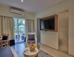 UtordaRoyal Orchid Beach Resort & Spa, Utorda Beach Goa的客厅配有电视、沙发和桌子