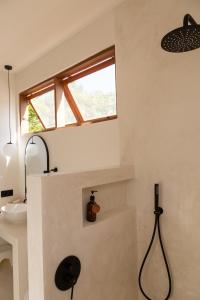 吉利阿尔Villa Luna - Gili Air的带淋浴和盥洗盆的浴室以及窗户。