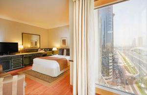 迪拜Millennium Plaza Downtown, Dubai的酒店客房设有一张床和一个大窗户