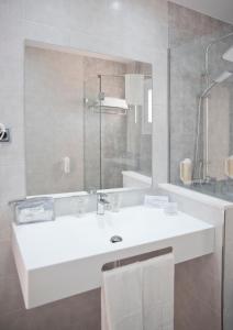 拉曼加戴尔马尔梅纳海豚酒店的浴室设有白色水槽和镜子