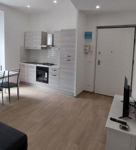 热那亚FIUMARA MALL Apartment的厨房配有白色橱柜、桌子和书桌。