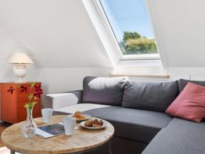 内克瑟Apartment Riitta - 250m from the sea in Bornholm by Interhome的客厅配有灰色沙发和桌子