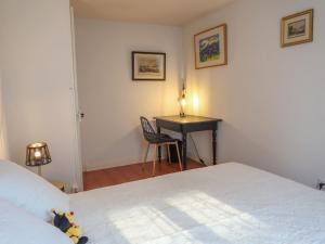 可利镇Apartment Petit nid de Pully by Interhome的一间卧室配有一张床和一张带台灯的书桌