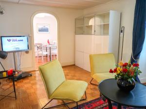 可利镇Apartment Petit nid de Pully by Interhome的客厅配有两把椅子、一张桌子和电视