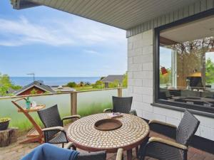 海斯勒Holiday Home Dika - 400m from the sea in Bornholm by Interhome的一个带桌椅的庭院和一个窗户。